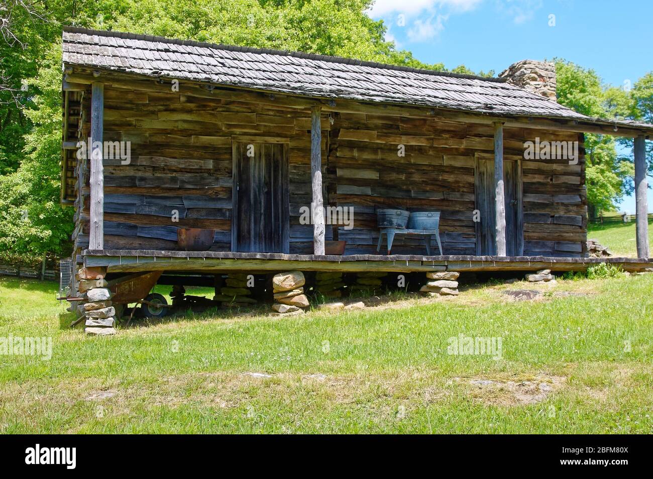 Vecchia cabina di tronchi, portico, 2 porte, vasche da lavanderia su stand, ombra, sole, Brush Mountain, Hensley Settlement; Cumberland Gap National Historic Park; Kentucky; Foto Stock