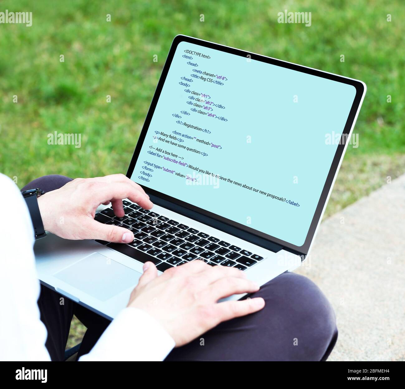 Uomo con notebook, la scrittura di codice di programmazione sul computer portatile Foto Stock