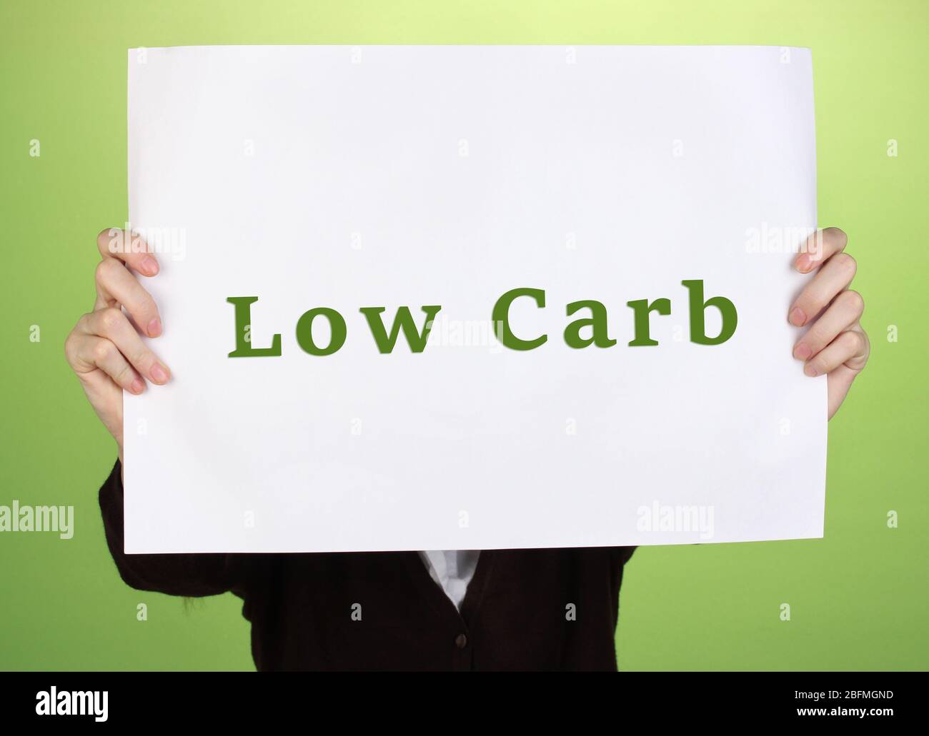 Donna che tiene carta con basso-Carb testo su sfondo a colori Foto Stock