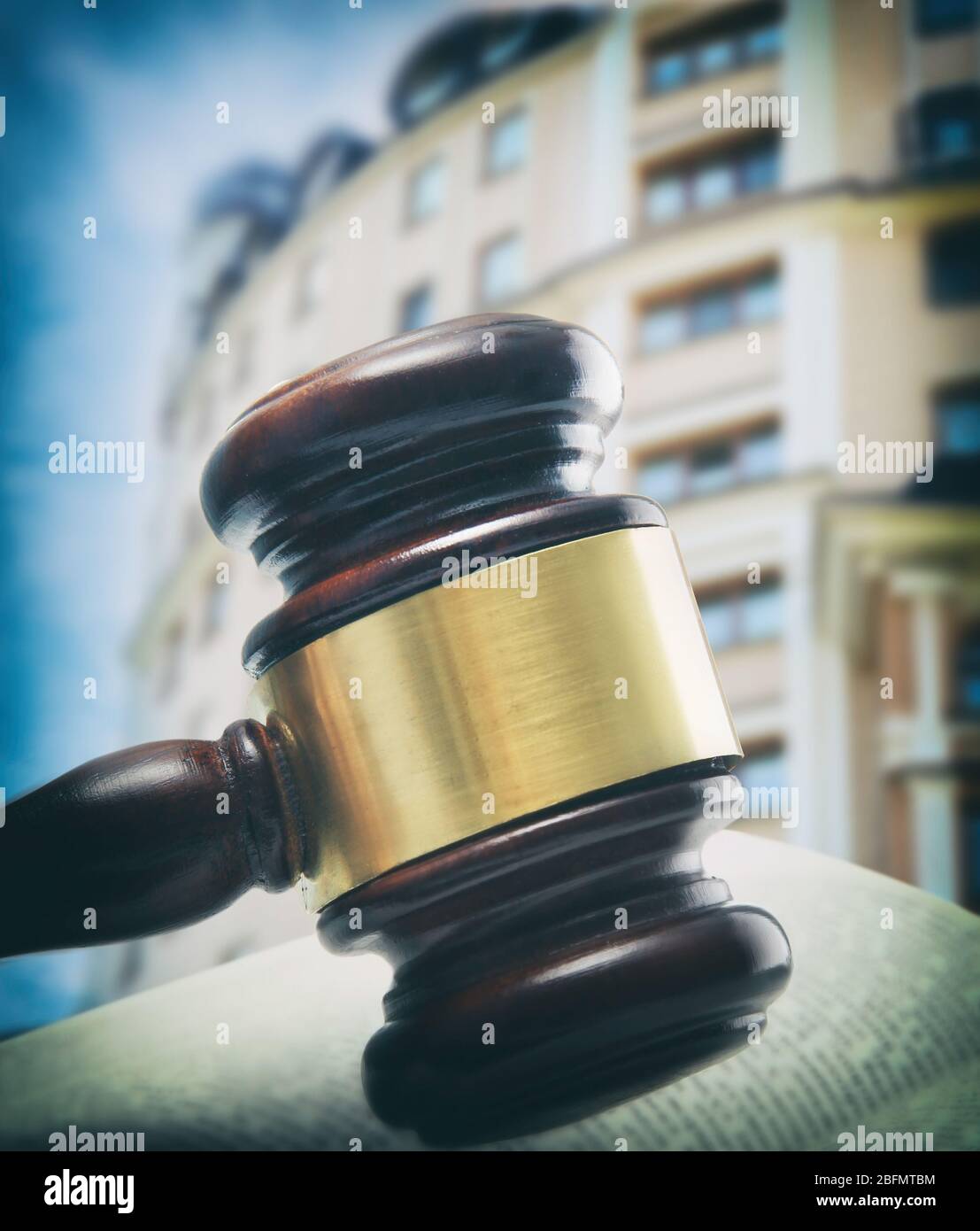 Gavel e libro su tavolo di legno sullo sfondo dell'edificio. Concetto di asta Foto Stock