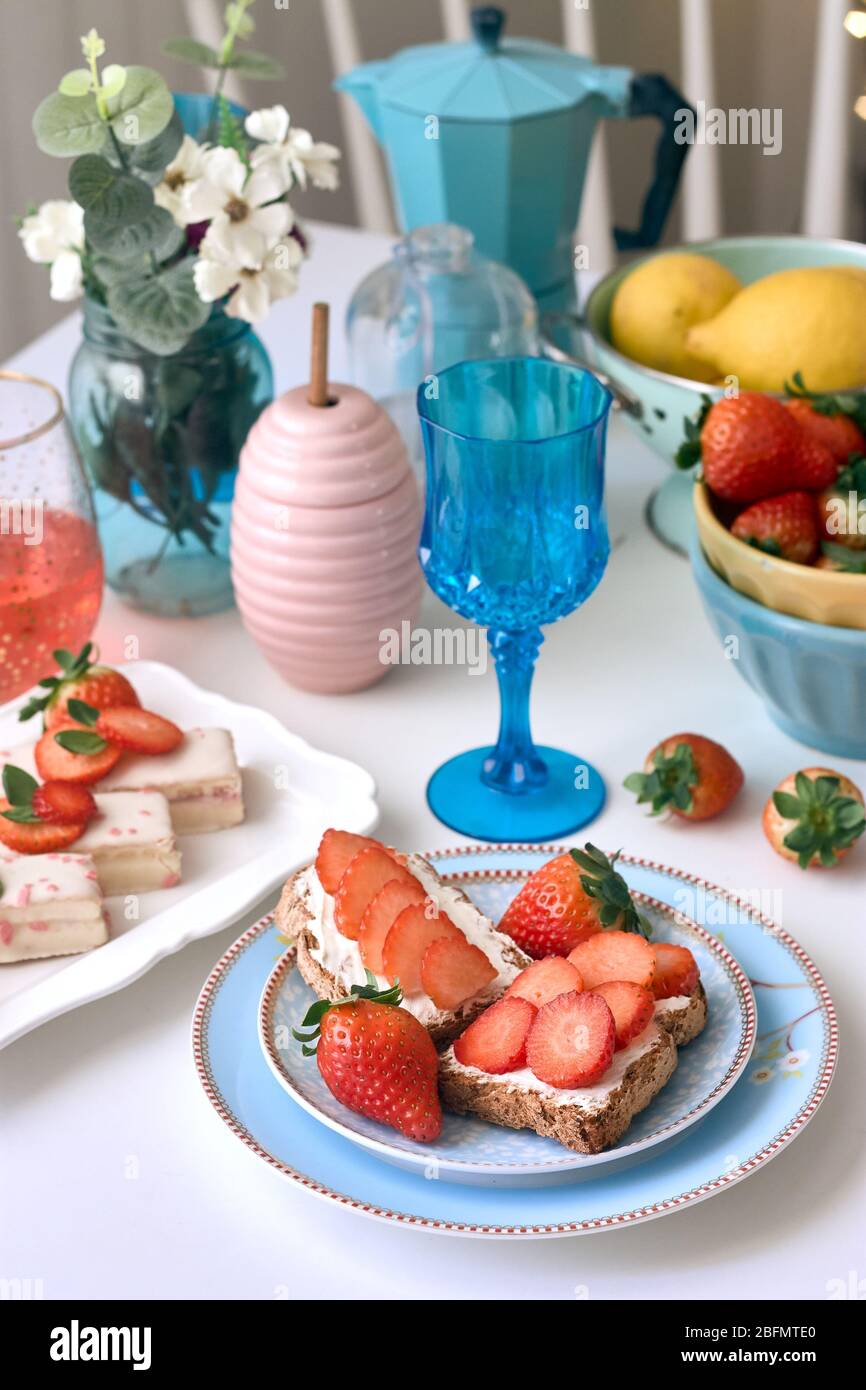 Toast al formaggio fresco con fragole accompagnato da una bevanda rossa. Foto Stock