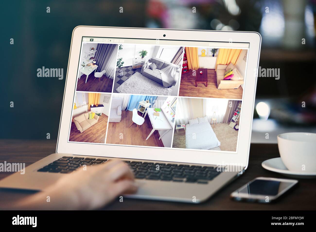 Donna che monitora le videocamere di sicurezza domestica sul laptop. Concetto di sistema di sicurezza domestica Foto Stock