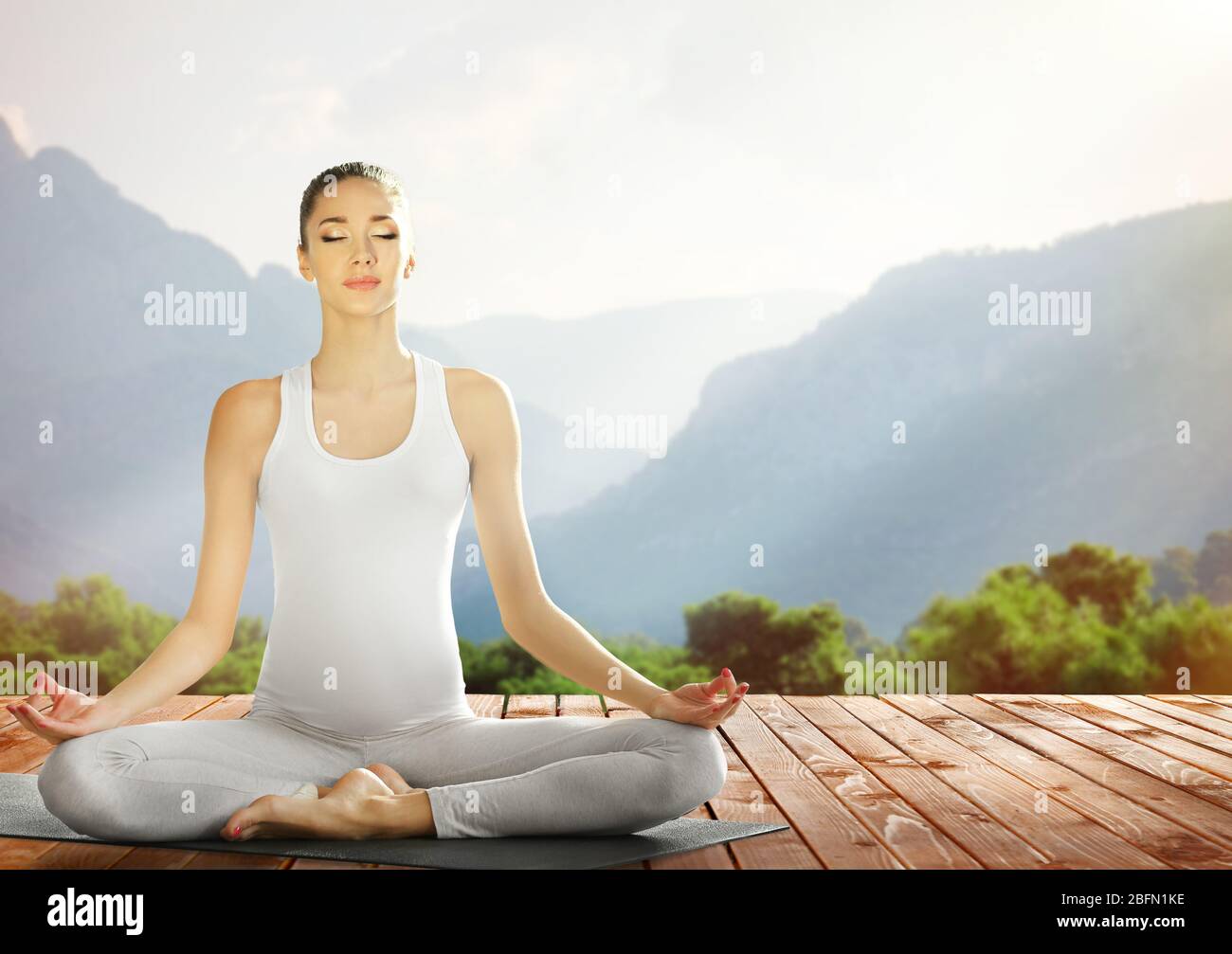 Bella giovane donna che fa yoga sulla natura Foto Stock