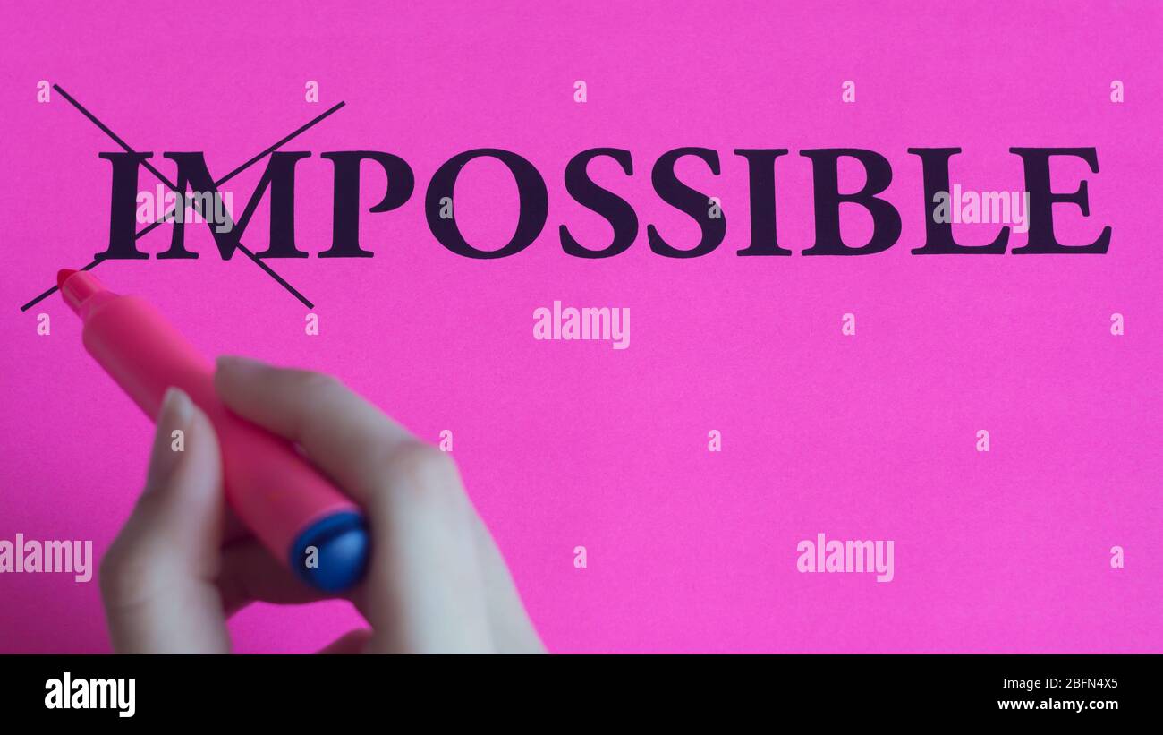 L'iscrizione motivazionale impossibile è possibile su sfondo rosa. Coaching, training, affermazioni. La mano della donna scrive la parola. La mano scrive la marca Foto Stock