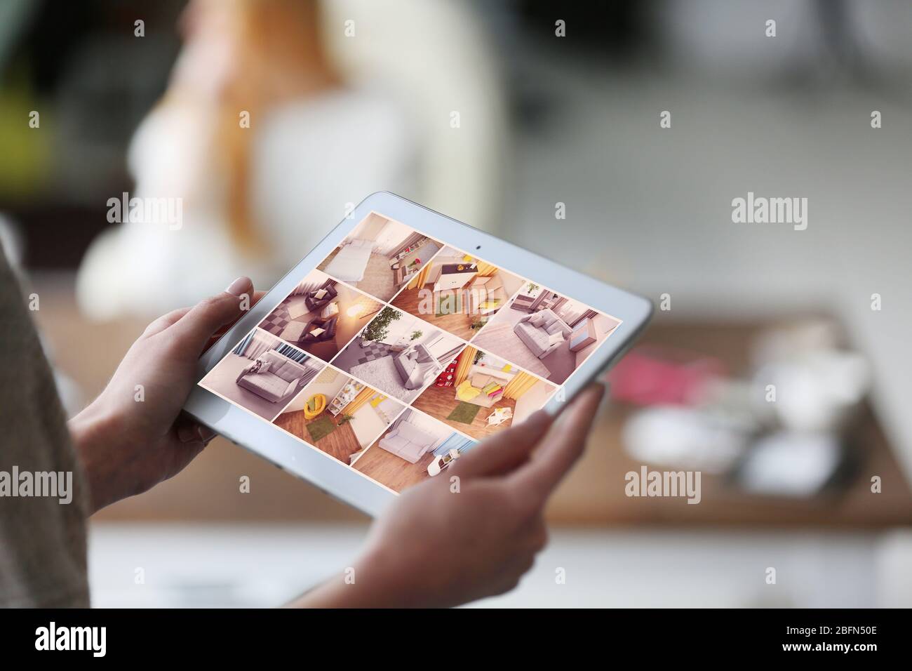 Donna che monitora le telecamere Live View sul display del tablet. Concetto di sistema di sicurezza domestica Foto Stock