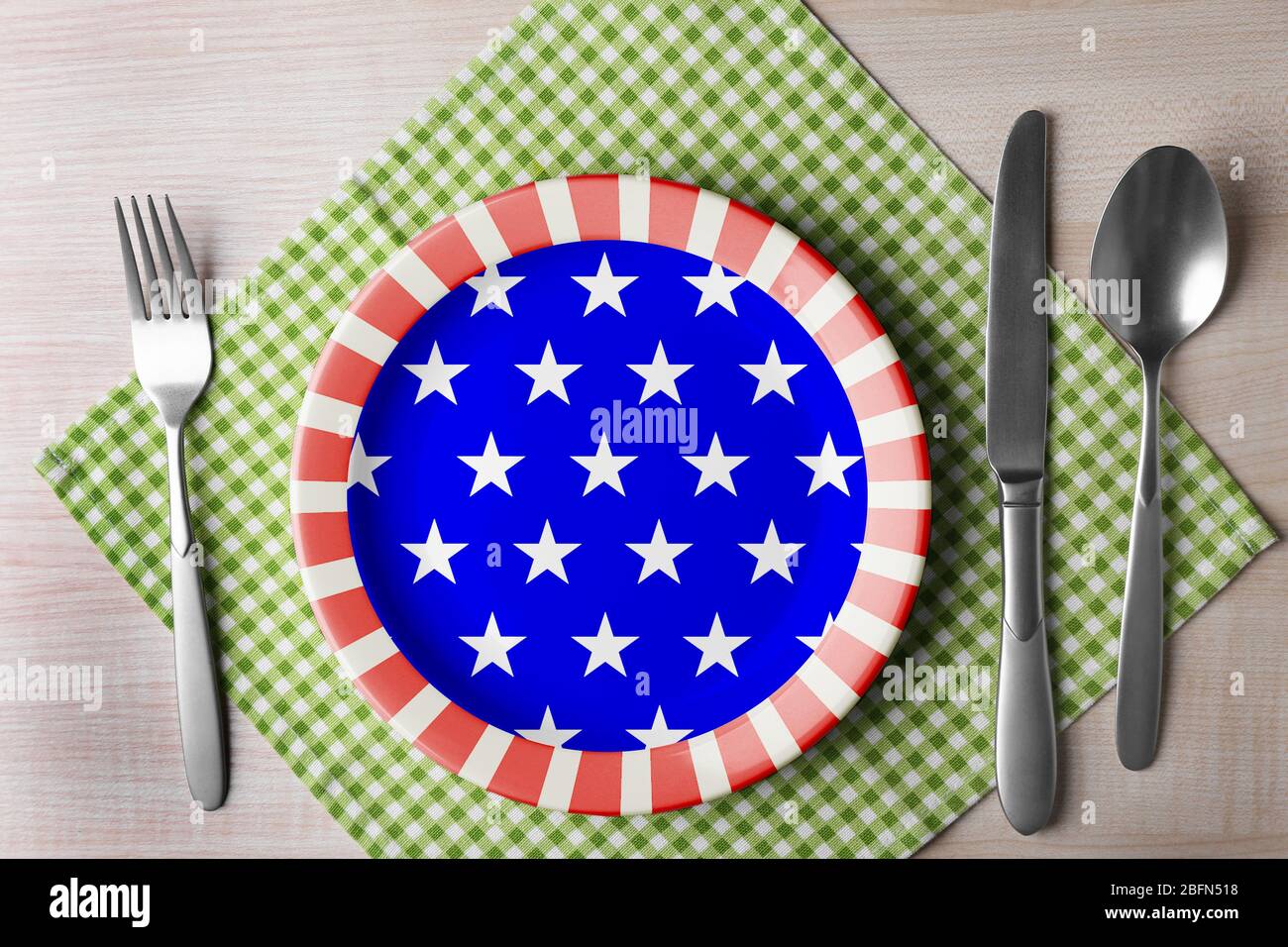 Piatto con posate in argento e tovagliolo su tavolo in legno, vista dall'alto. Cucina americana concetto di cibo Foto Stock