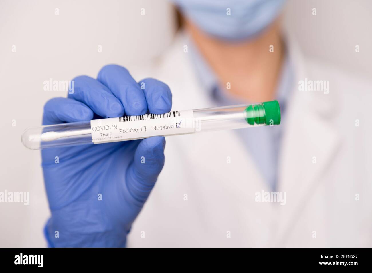 Covid test nelle mani di un medico con blu guanti Foto Stock