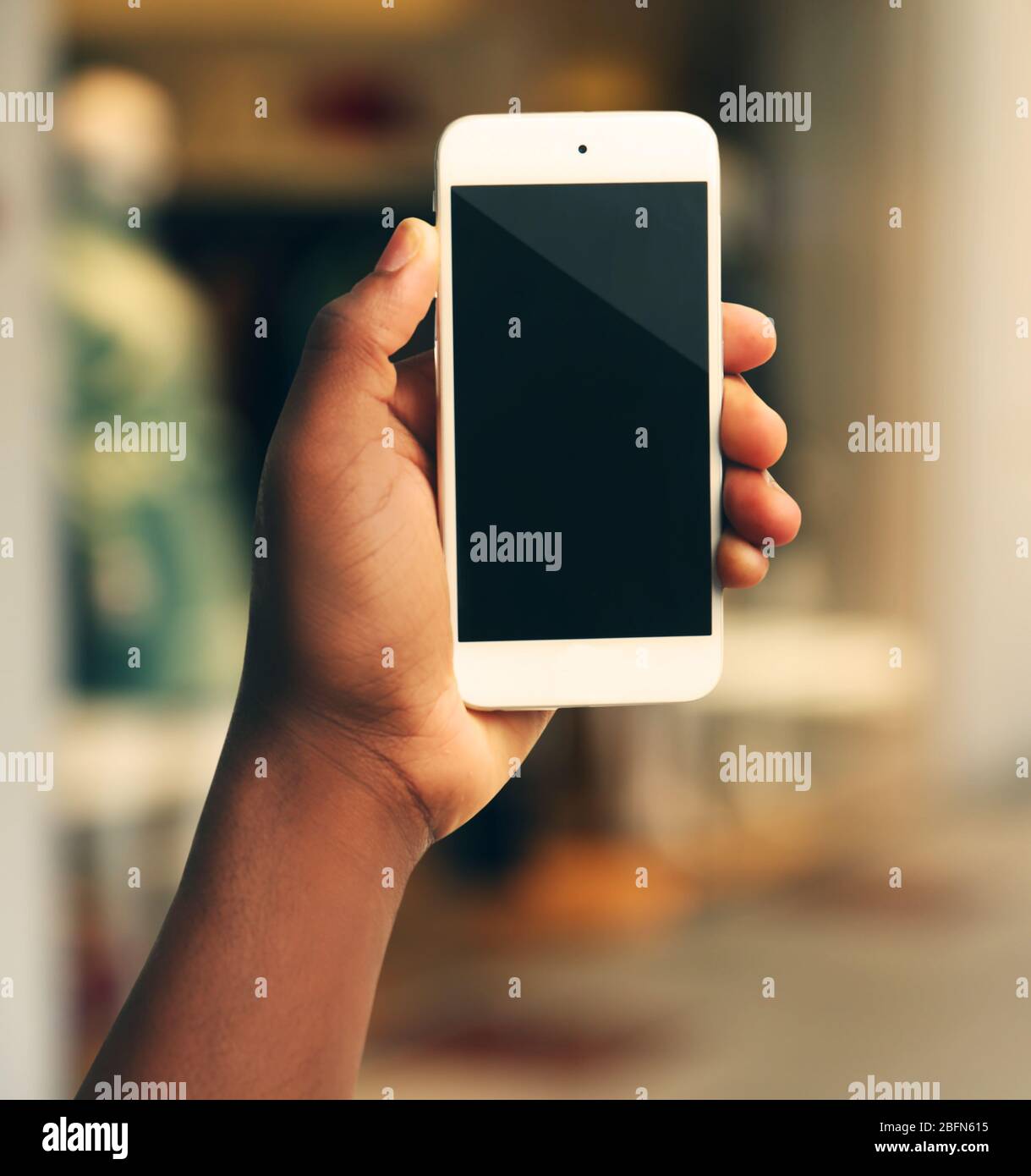 Mans Hand mostra smartphone mobile, sfondo sfocato Foto Stock