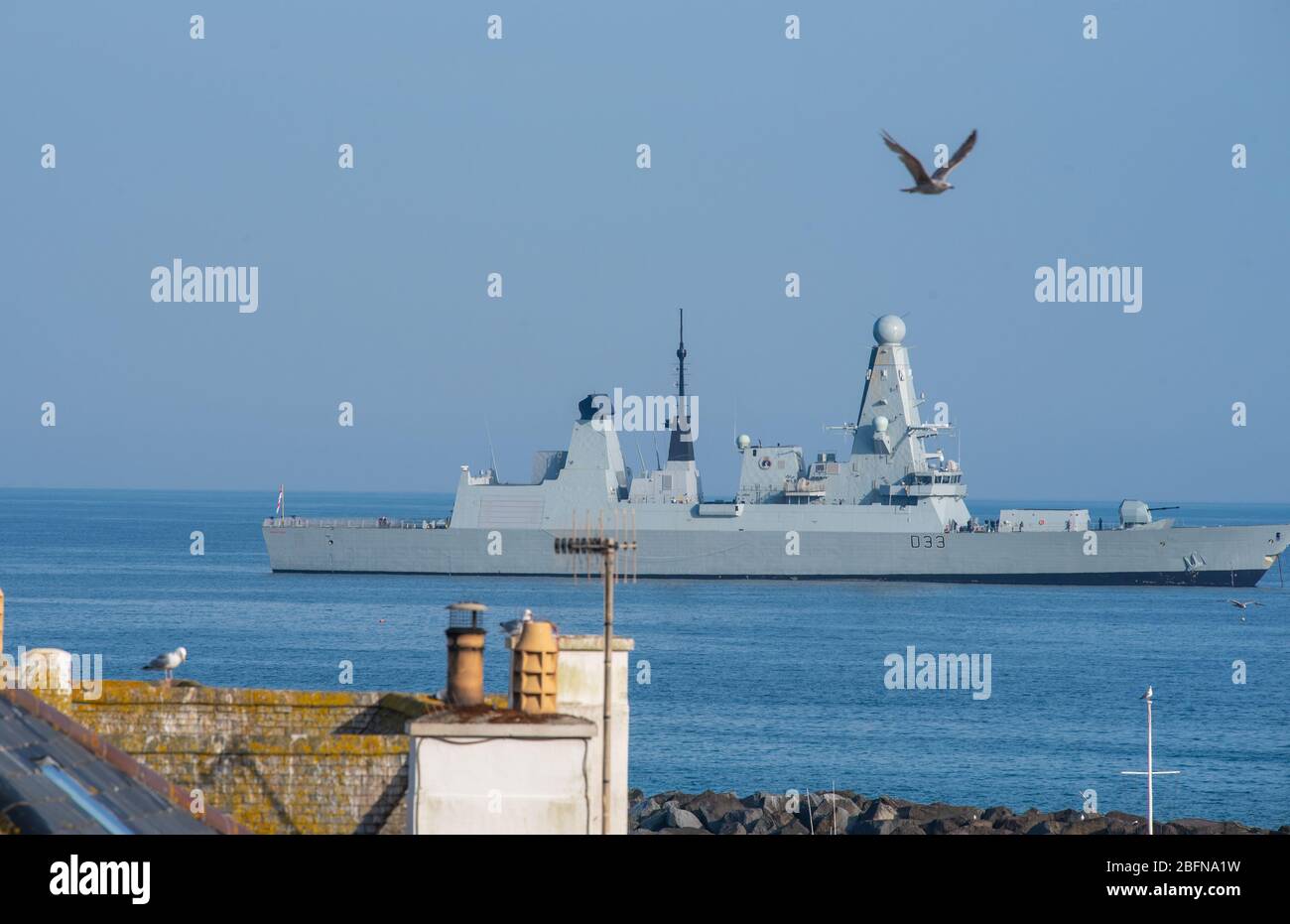 Lyme Regis, Dorset, Regno Unito. 19 Apr 2020. UK Weather: Royal Navy Type 45 Destroyer HMS Dauntless osserva le distanze sociali in un pomeriggio caldo e soleggiato durante il blocco del coronavirus. Si è sentito un annuncio che ricorda alla compagnia della nave di rimanere a 2 metri di distanza quando sul ponte. Credit: Celia McMahon/Alamy Live News Foto Stock