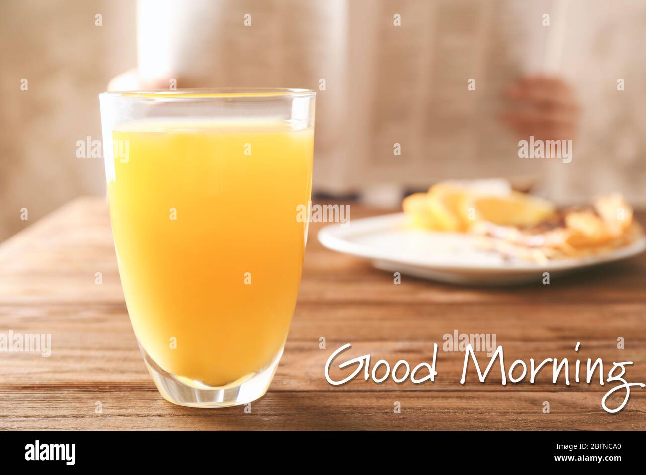 Bicchiere di succo d'arancia su tavolo di legno. Testo BUONGIORNO sullo sfondo Foto Stock