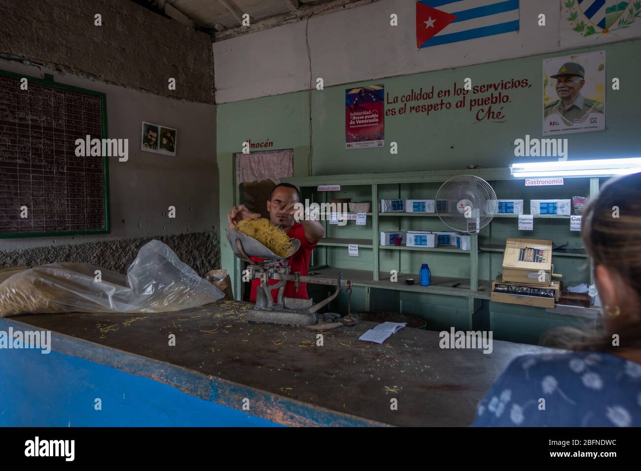 Uomo che serve una porzione di pasta in un negozio di razione a Salvador Cisneros, Viñales, Cuba Foto Stock
