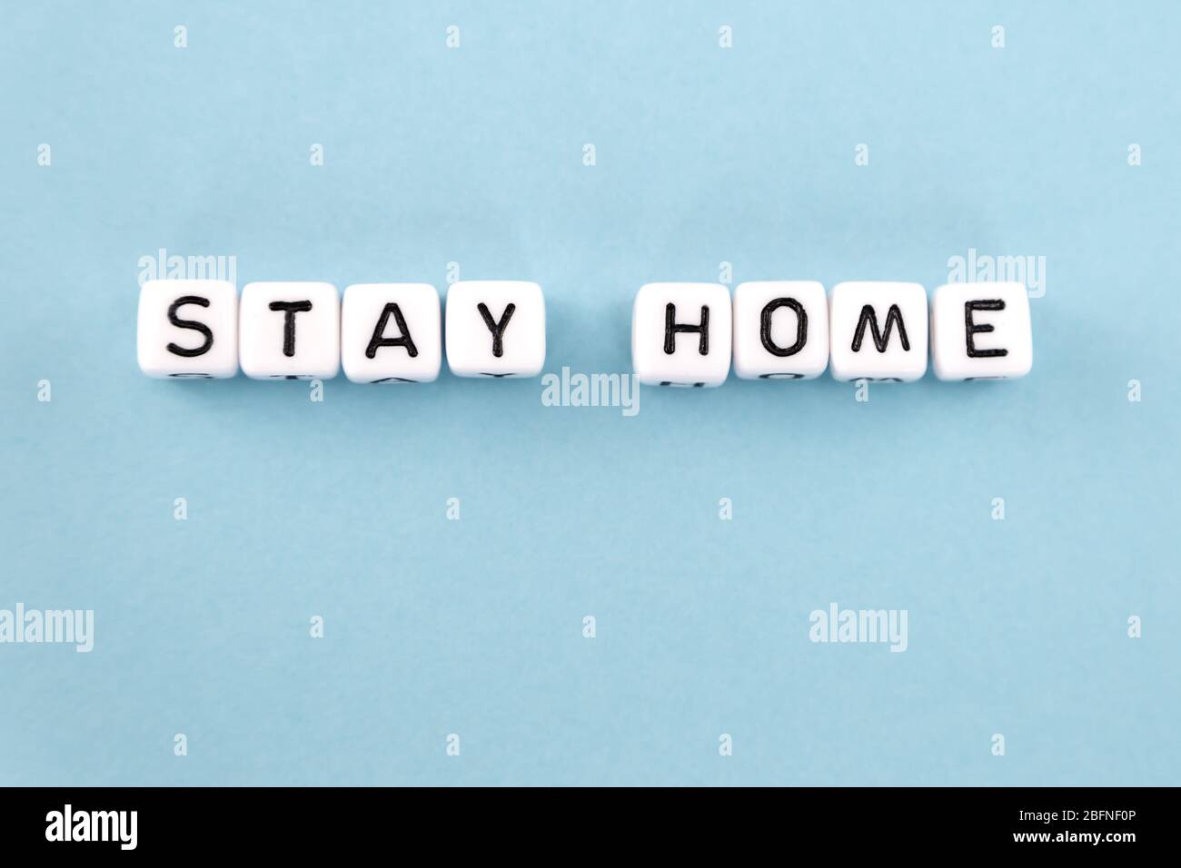 frase di soggiorno a casa composta da cubi su sfondo blu Foto Stock