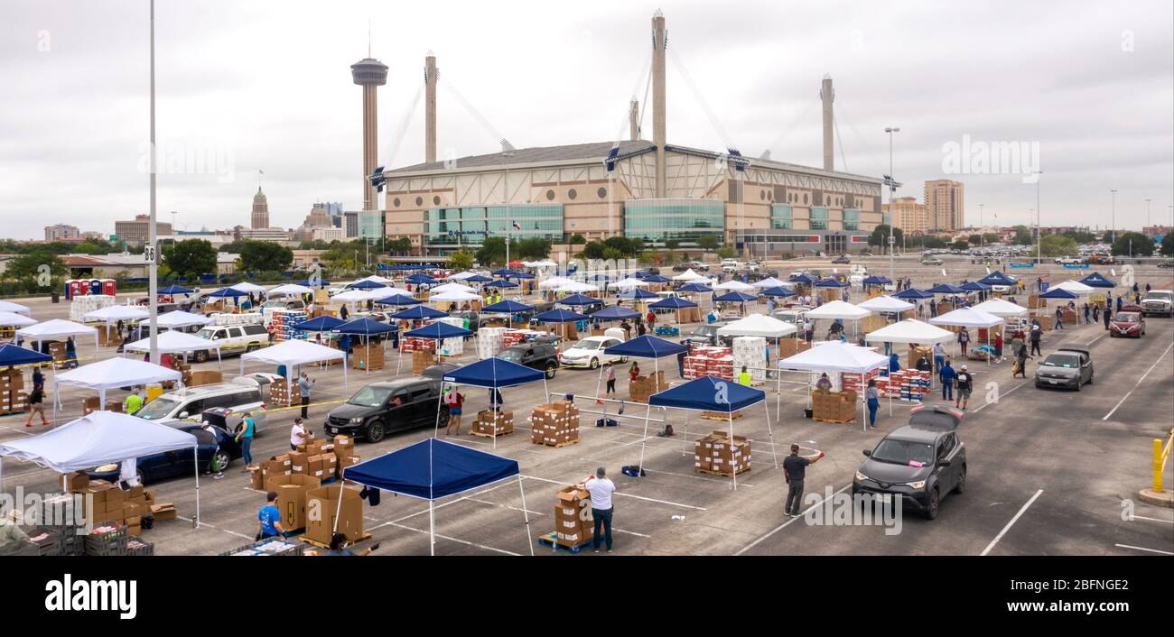 Vista aerea di centinaia di auto schierate per ricevere USDA Food and Nutrition Service e San Antonio Food Bank aiuti alimentari alle famiglie che soffrono degli effetti del COVID-19, pandemia di coronavirus al Alamodome 17 aprile 2020 a San Antonio, Texas. Foto Stock