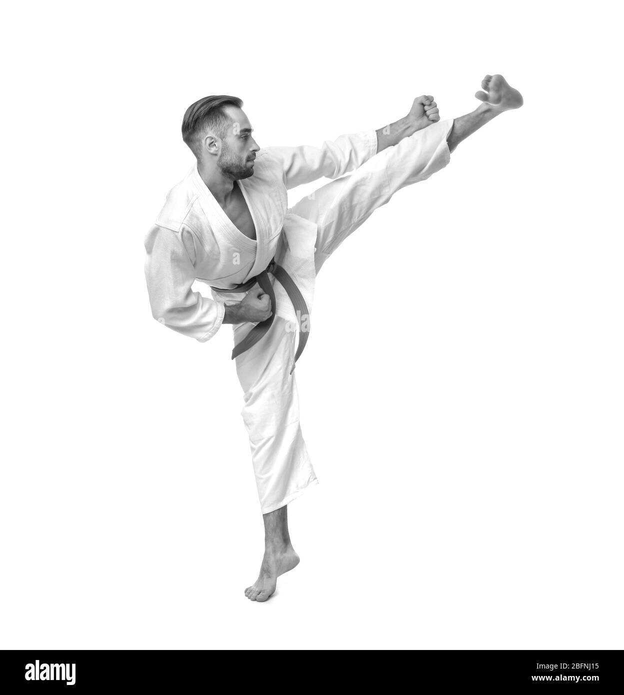 Giovane uomo che pratica il karate su sfondo bianco Foto Stock