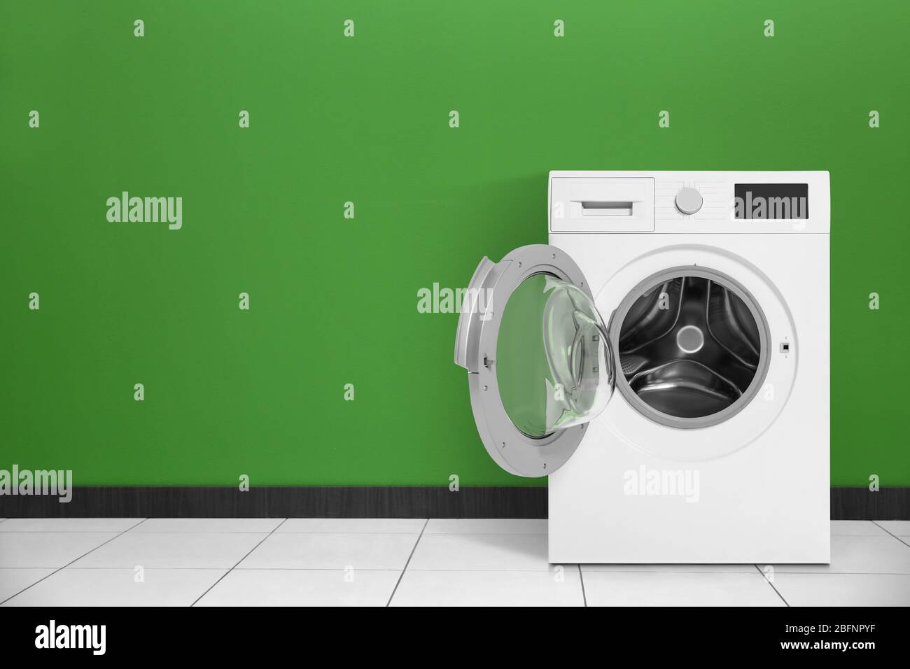 Lavatrice moderna vicino a pareti a colori all'interno. Giorno di lavanderia Foto Stock