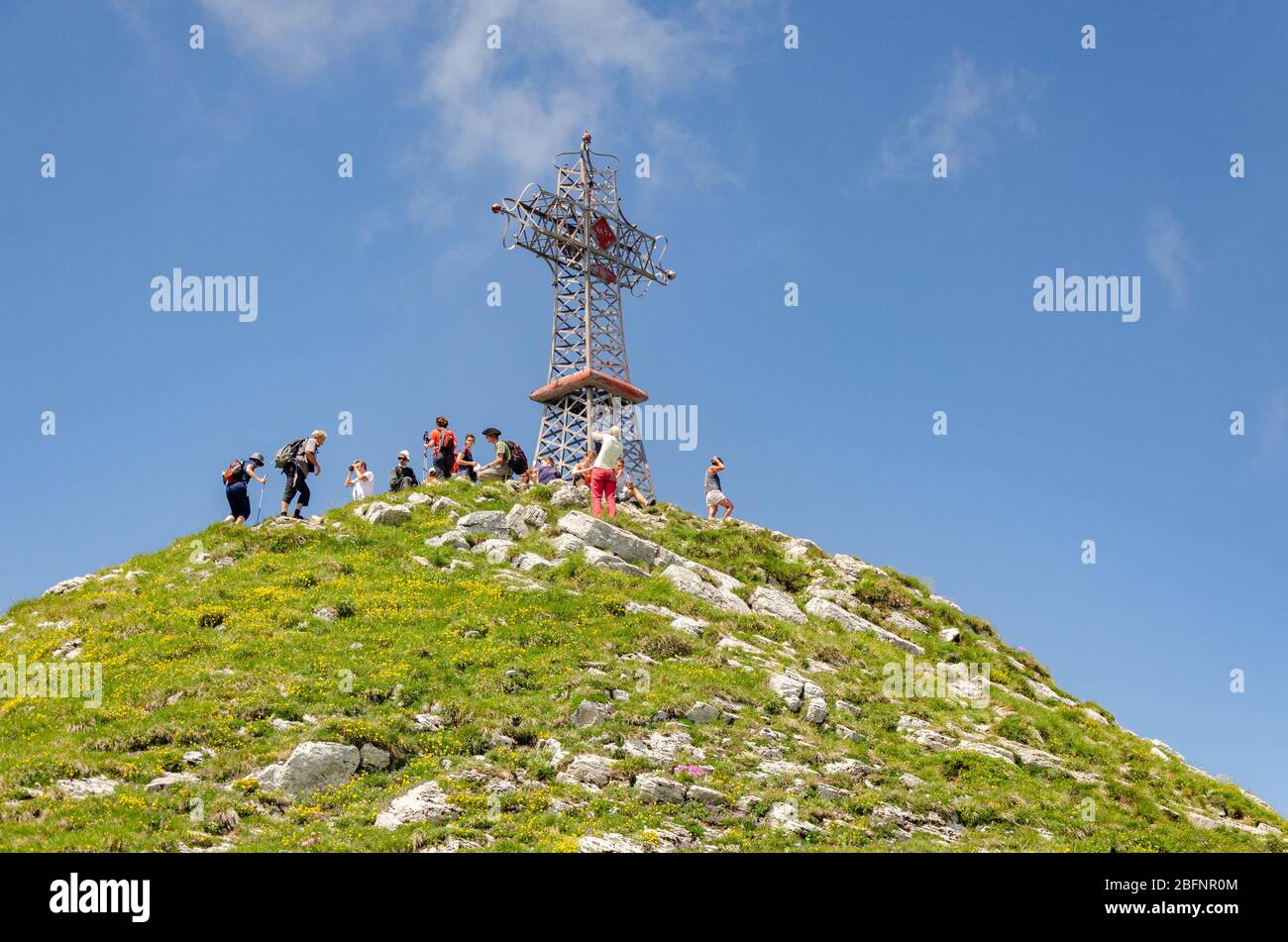 Vista degli escursionisti e la croce sulla cima di le Reculet sulle montagne del Giura, Francia Foto Stock