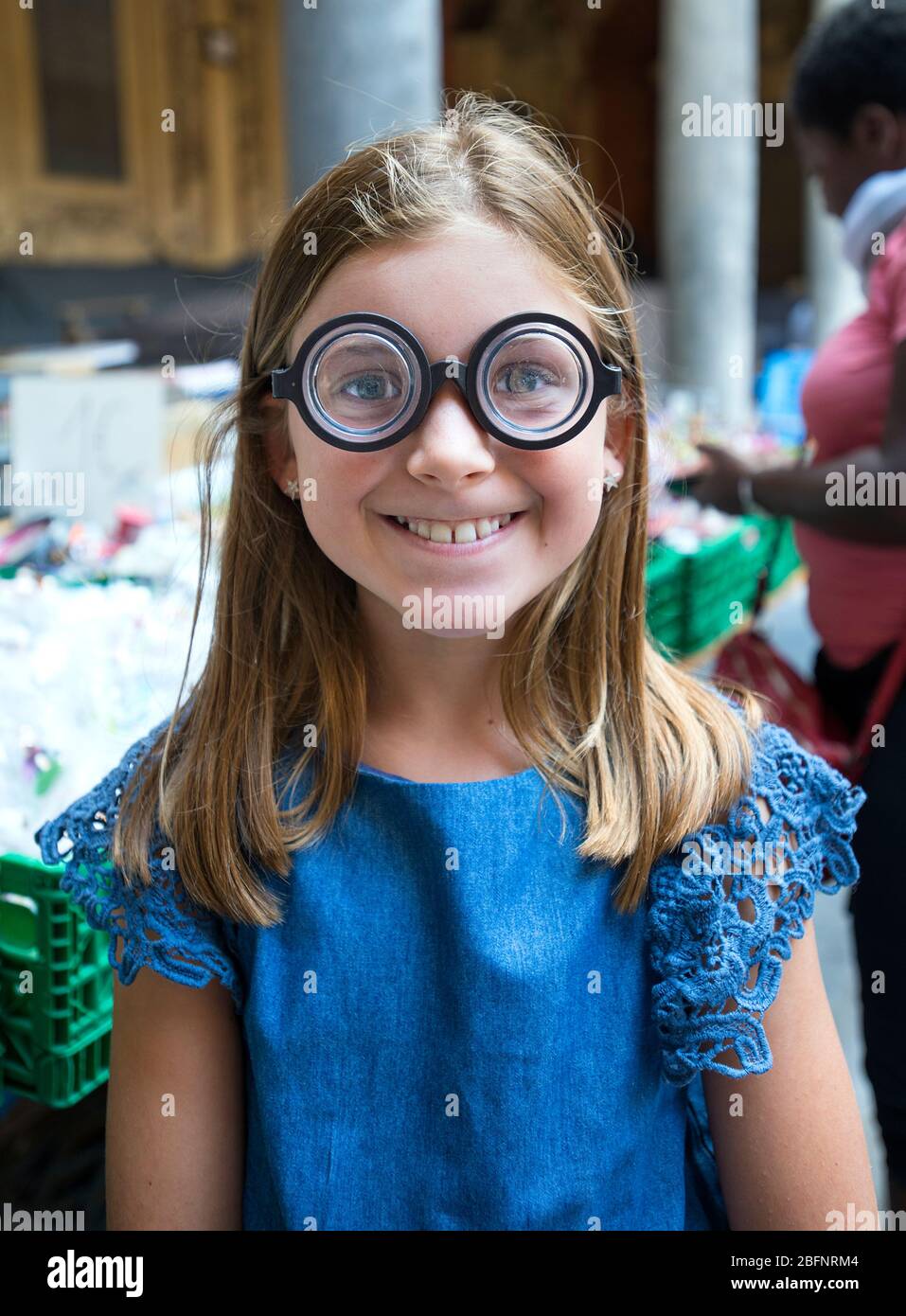 Giovane ragazza sorridente che indossa occhiali di plastica Foto Stock