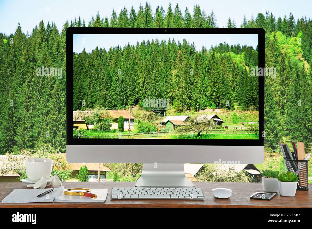 Immagine concettuale di uno spazio di lavoro e desktop con piccolo villaggio in montagna Foto Stock