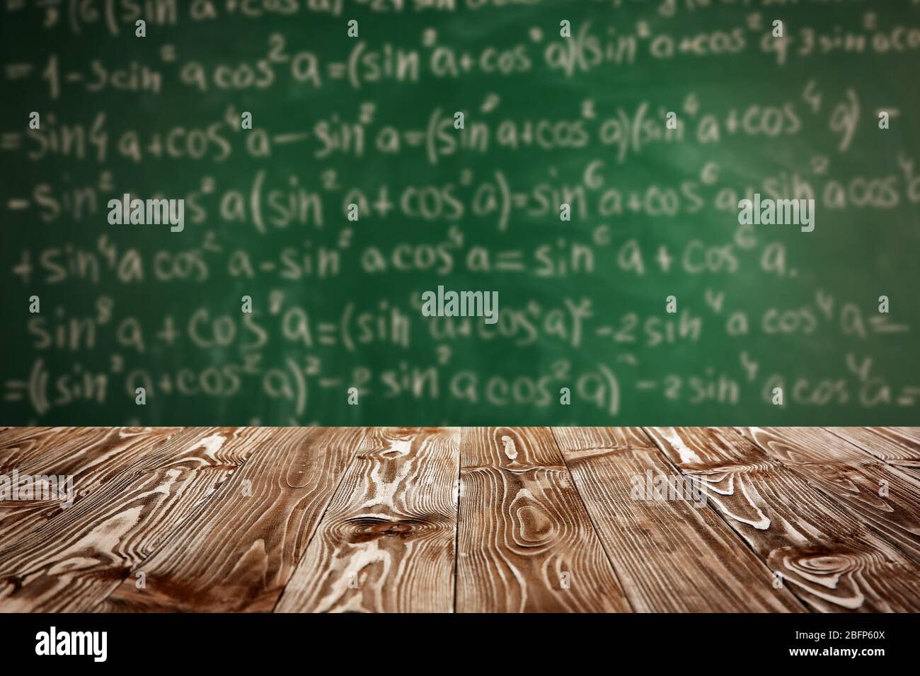 Tavolo in legno su sfondo lavagna. Concetto scolastico. Foto Stock