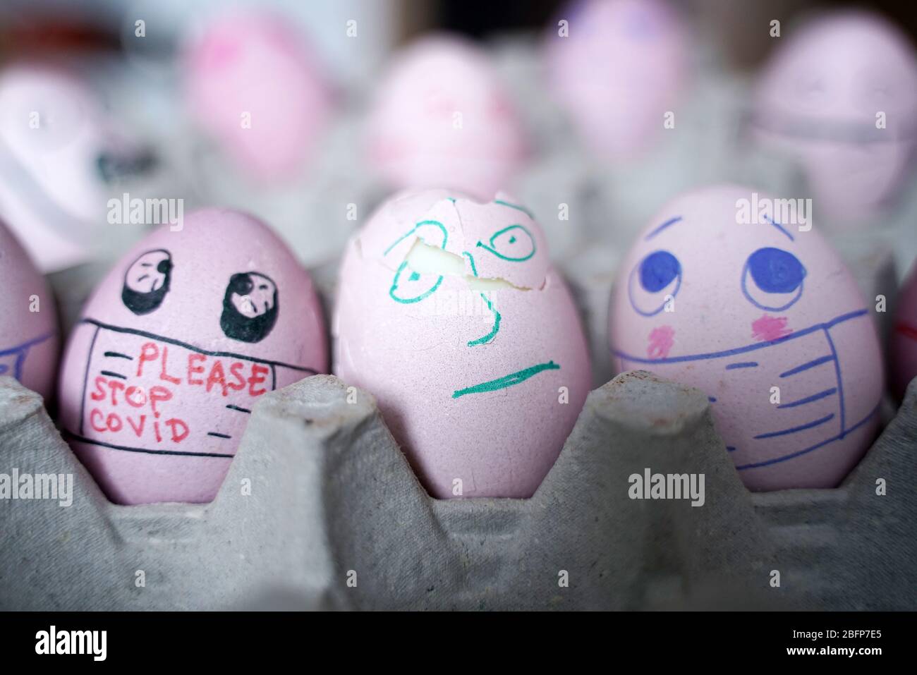 Fatevi uova di pasqua con maschera per le feste di Pasqua decorazione. Messa a fuoco selettiva con spazio di copia. Protezione COVID-19. Uova di Pasqua con Corona Foto Stock
