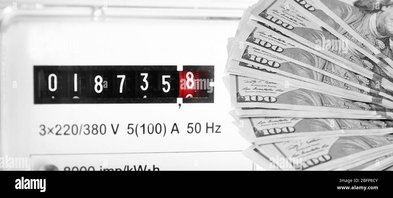 Dollari americani e contatore elettrico di sfondo. Foto Stock