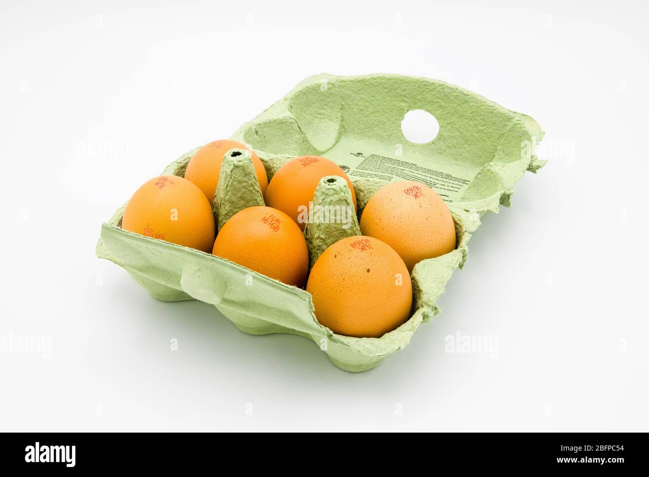 Eggbox di cartone verde, completamente aperto, contenente mezza dozzina di uova di gallina fresche marroni speckled dal Regno Unito, su uno sfondo bianco Foto Stock