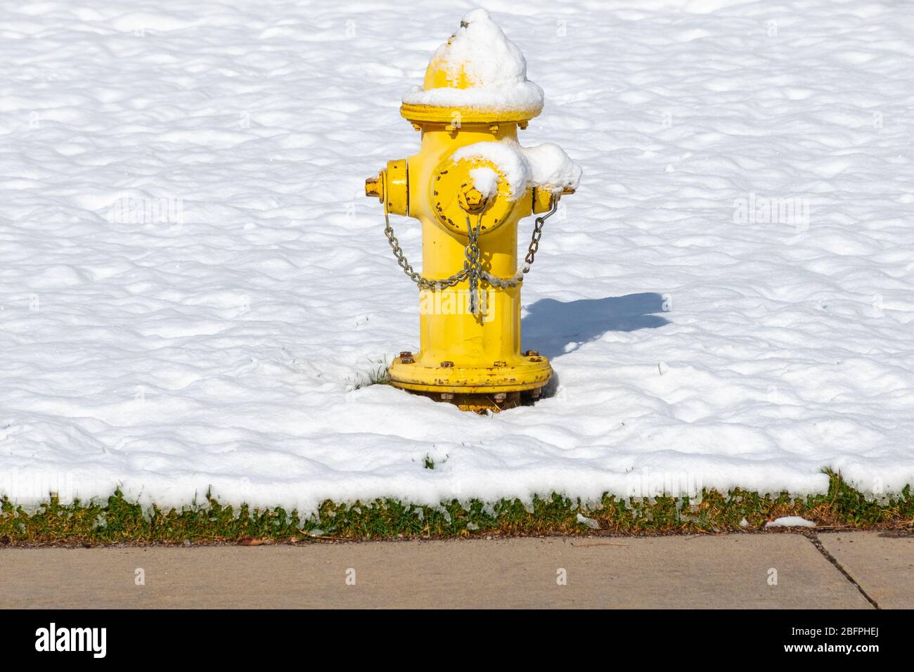 Un idrante giallo acceso sulla neve Foto Stock