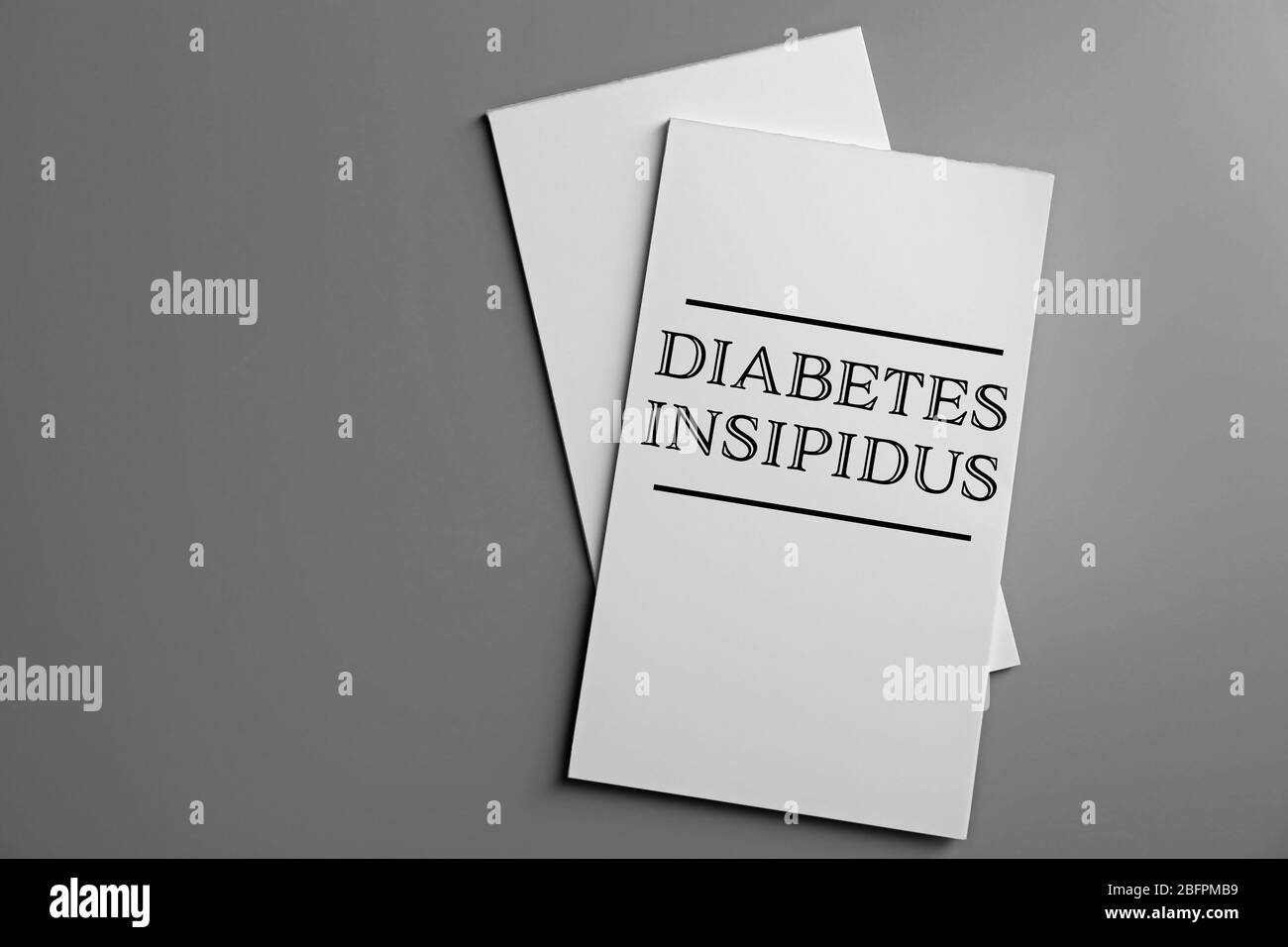 Concetto di assistenza sanitaria. Opuscolo con titolo DIABETE INSIPIDO su sfondo grigio Foto Stock