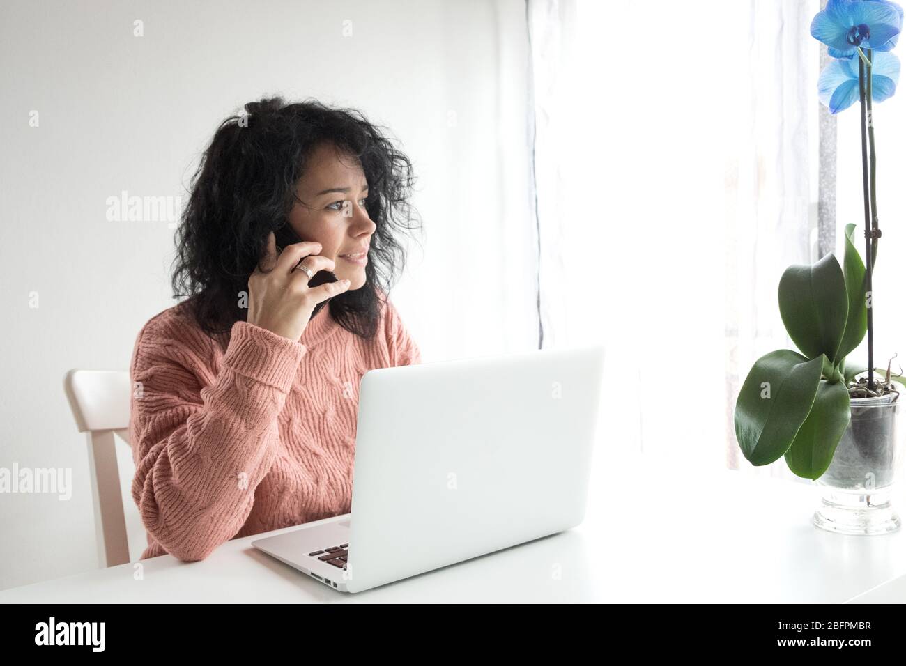 una donna intraprendente lavora da casa con il computer Foto Stock