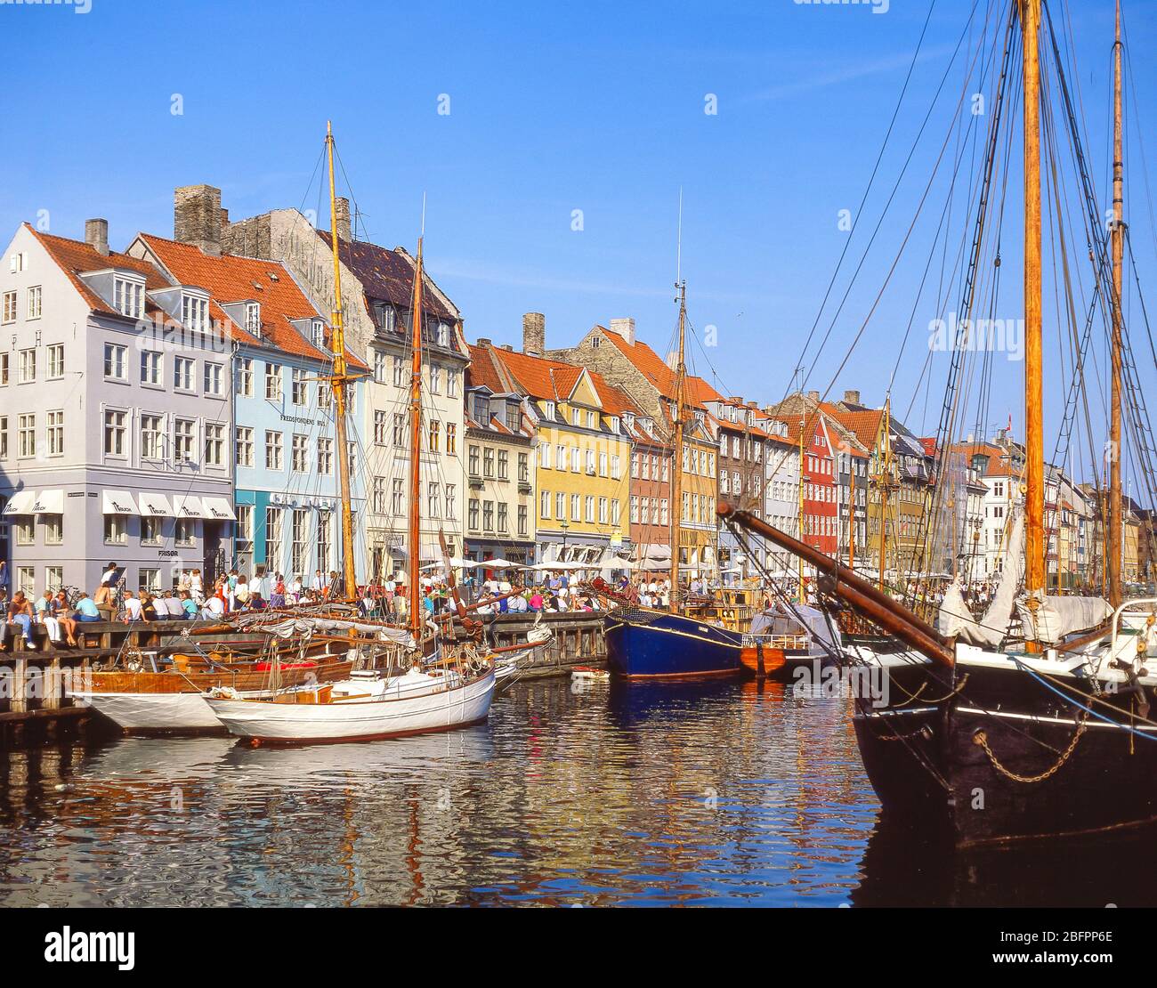 Magazzini colorati e barche a vela, Nyhaven Canal, Indre by, Copenhagen (Kobenhavn), Regno di Danimarca Foto Stock