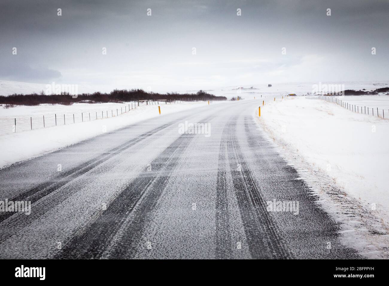 La circonvallazione meridionale con vento che soffia neve attraverso la strada in una giornata ventosa in Islanda, Nord Europa Foto Stock