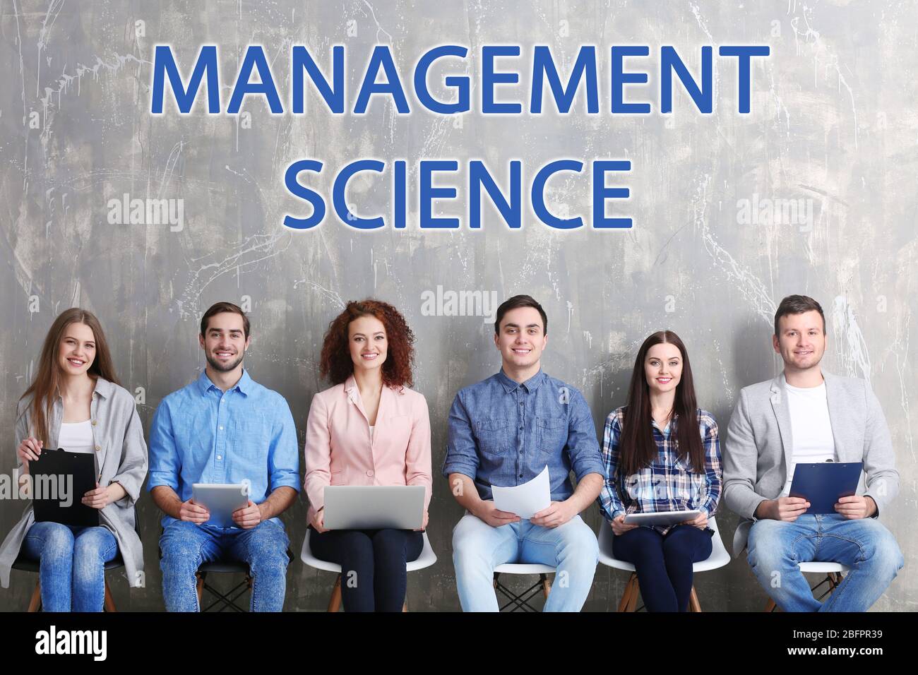 Concetto di scienza di gestione. Giovani seduti su sedie contro il muro di sfondo grunge Foto Stock