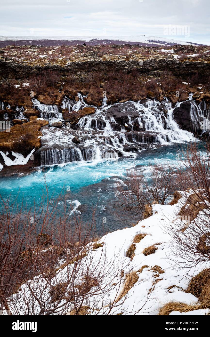 Cascate di Hraunfossar che si innaldissero nel fiume Hvita alimentato dai ghiacciai in Islanda in inverno Foto Stock