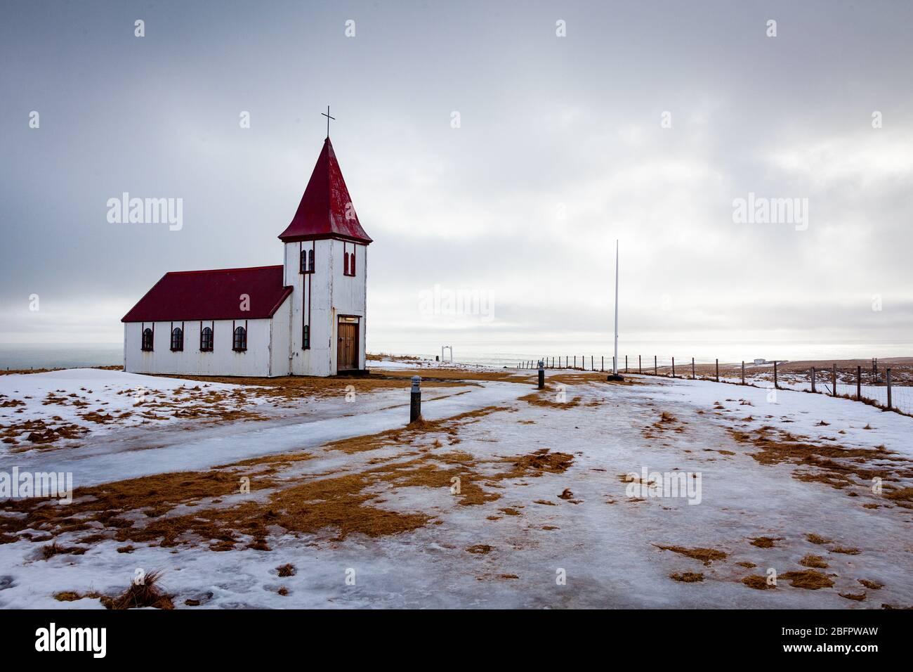 La chiesa di Hellnakirkja con il tetto rosso a Hellnar nella penisola di Snaefellsnes sulla neve in una giornata invernale, l'Islanda Foto Stock