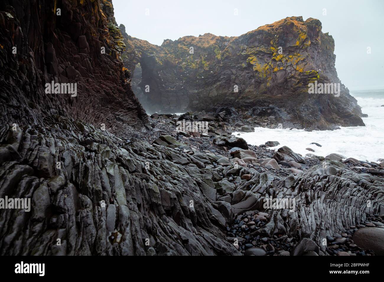Formazioni rocciose di lava basaltica sulla spiaggia di Djupalonssandur Dritvik ai piedi del vulcano Snaefellsjokull, Islanda Foto Stock