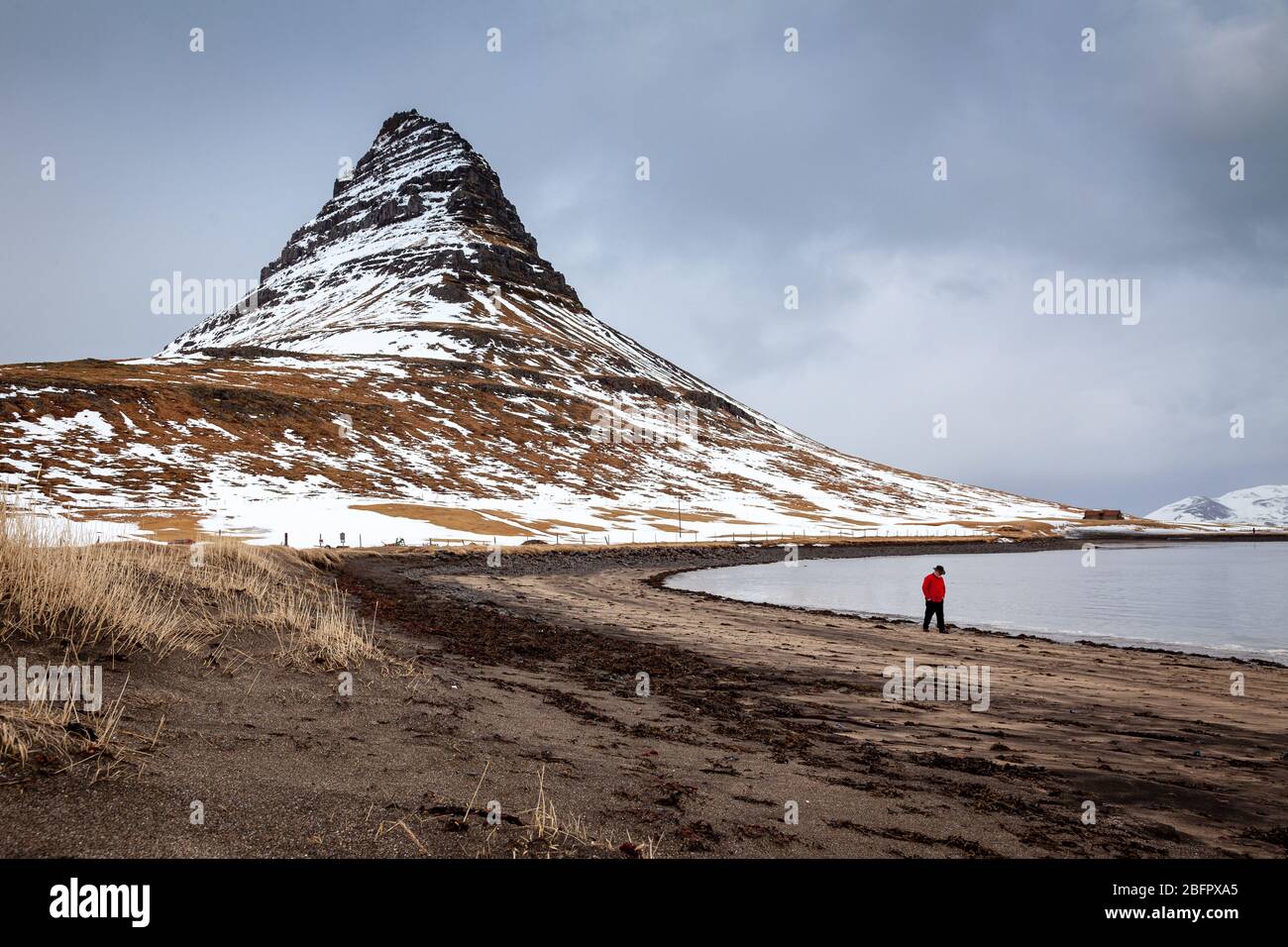 Montagna di Kirkjufell coperta di neve con un lago ghiacciato, Grundarfjordur, Penisola di Snaefellsnes, Islanda Foto Stock