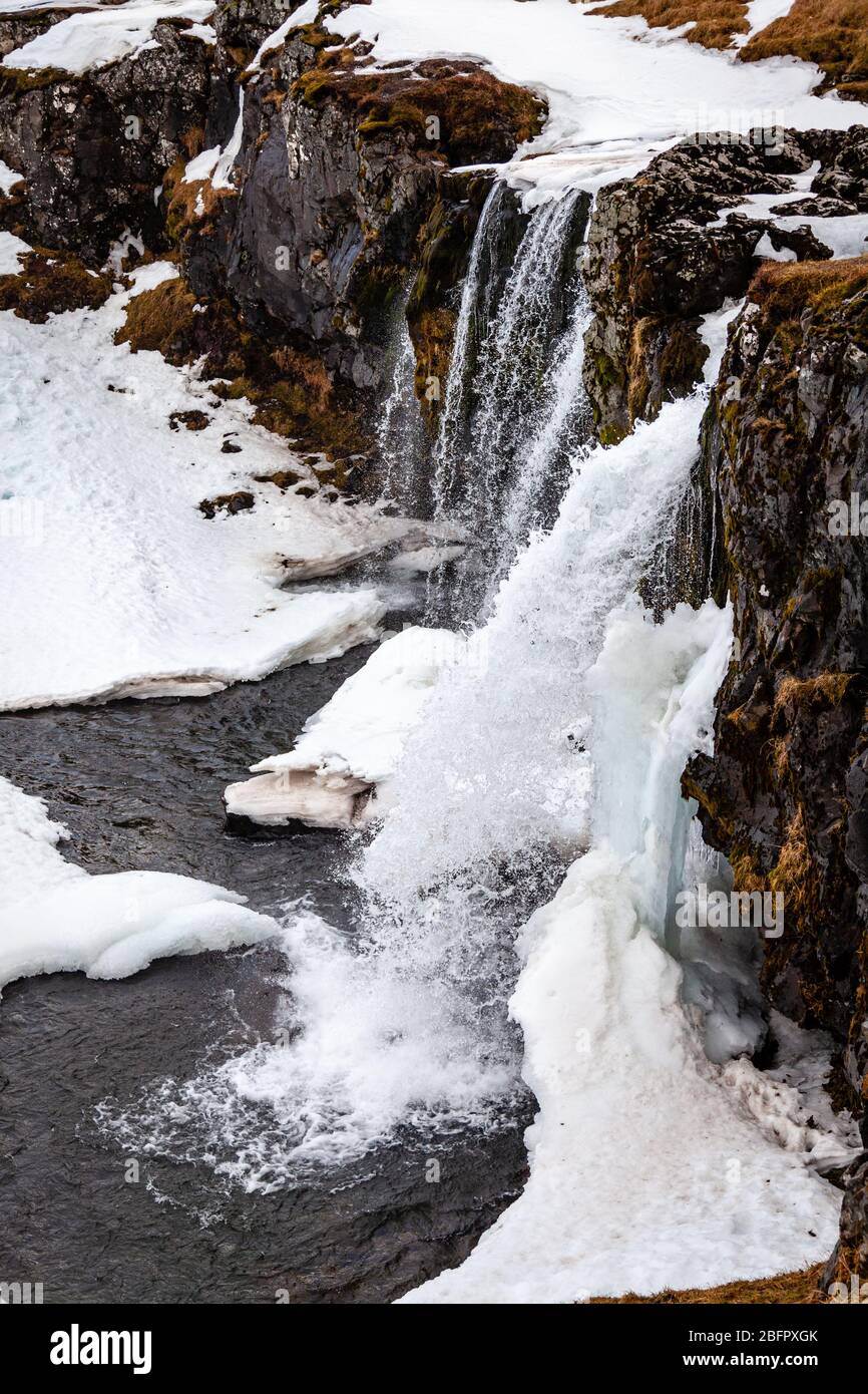 Cascata di Kirkjufellsfoss congelata nel sud-ovest dell'Islanda in una giornata innevata d'inverno Foto Stock