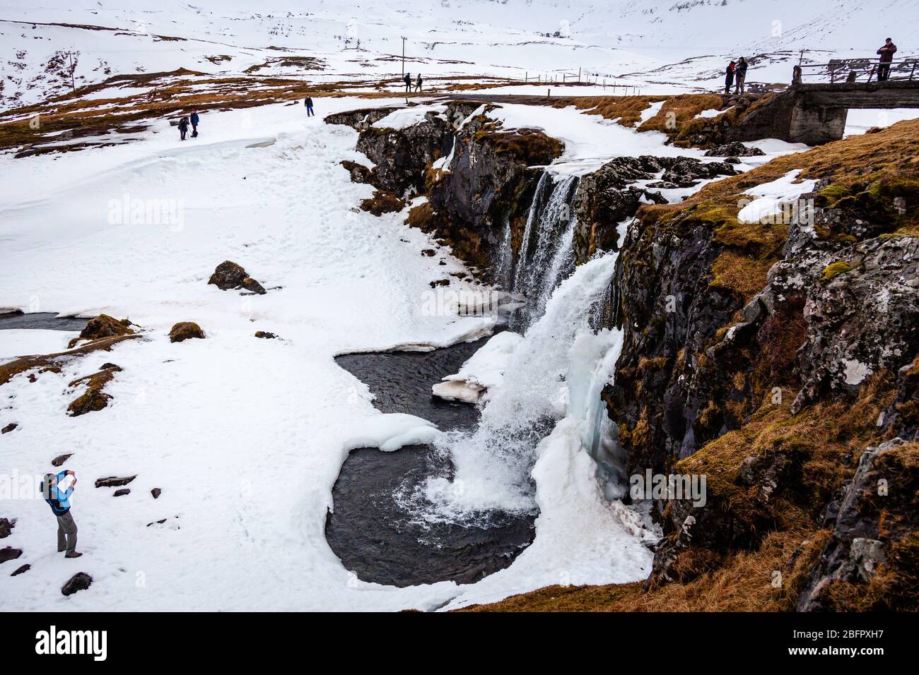Cascata di Kirkjufellsfoss congelata nel sud-ovest dell'Islanda in una giornata innevata d'inverno Foto Stock
