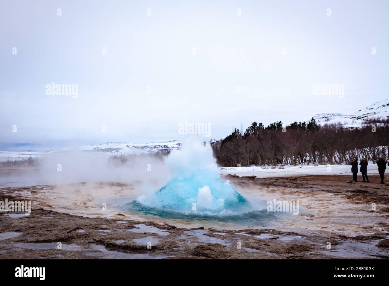 Geysir, Islanda - le sorgenti termali di Strokkur nella zona geotermica di Geysir eruttano in una giornata nuvolosa in inverno Foto Stock