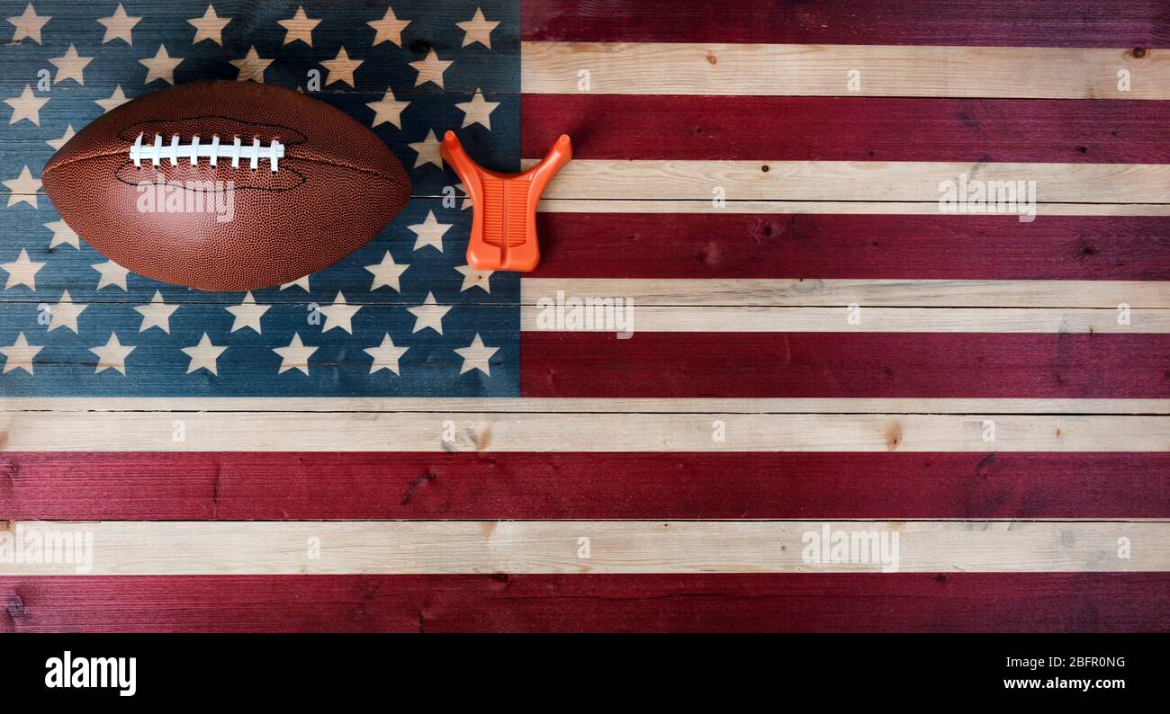 Calcio americano con tee calciante su sfondo vintage della bandiera degli Stati Uniti. Concetto di sport calcistici con spazio per la copia Foto Stock