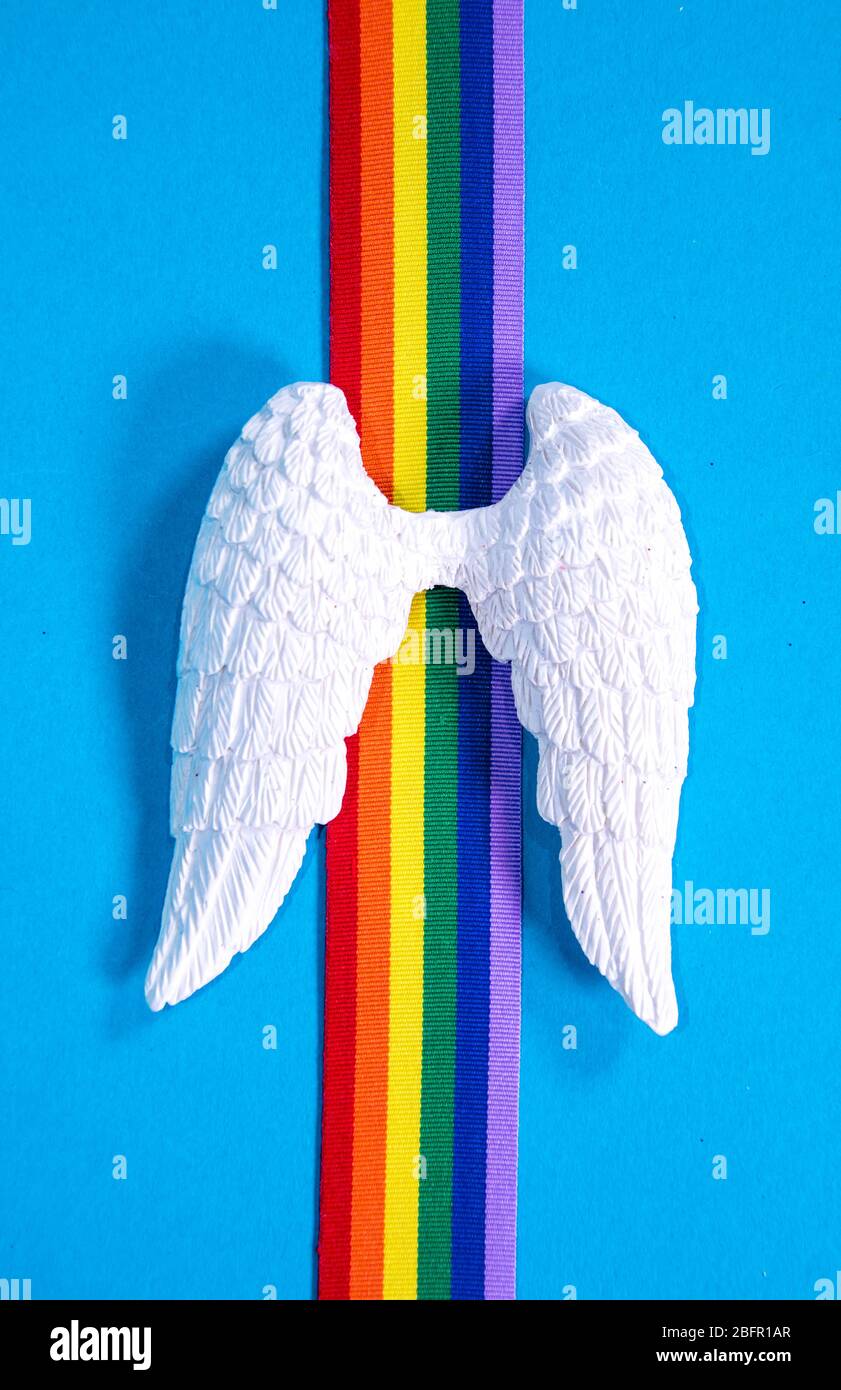 Un set di ali d'angelo bianche con nastro arcobaleno colorato, per ricordare coloro che sono morti. Foto Stock