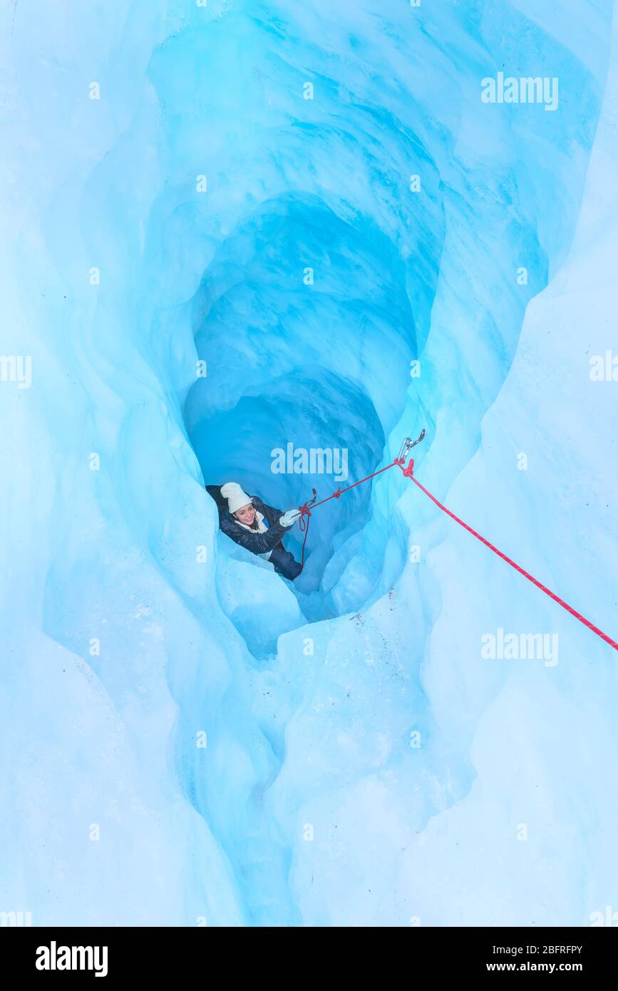 Alpinista che si muove su grotta di ghiaccio, Fox Glacier, South Island, Nuova Zelanda, Foto Stock