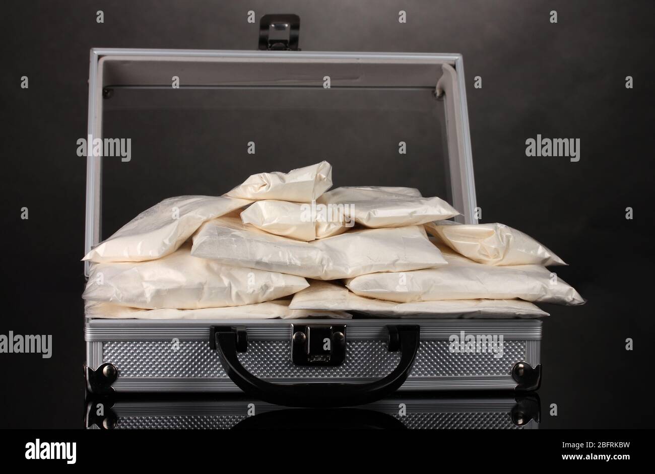 Cocaina in valigia su sfondo grigio Foto Stock