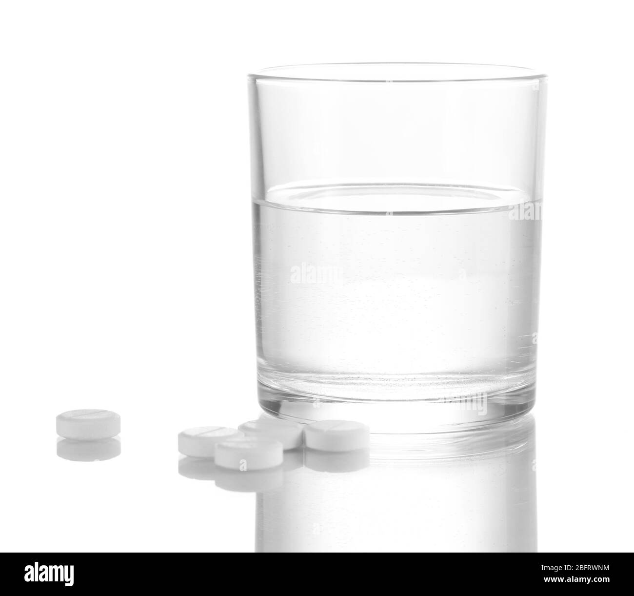 Bicchiere d'acqua e pillole isolato su bianco Foto Stock