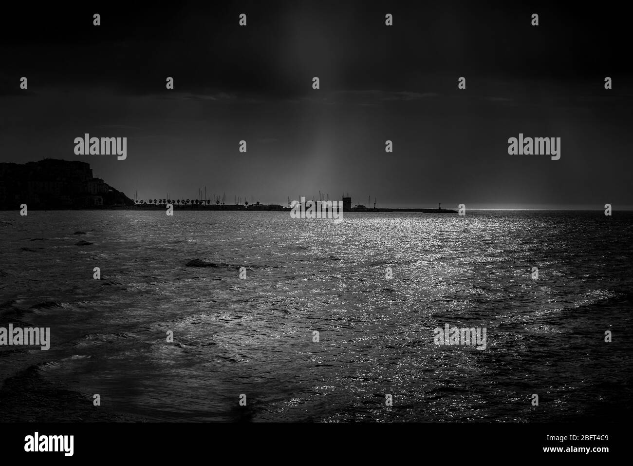 Estate cielo drammatico con tempesta sul mare al largo della costa della penisola del Gargano. Sullo sfondo il porto di Rodi Garganico. Foto Stock