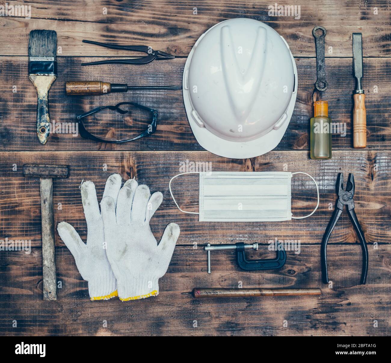 Concetto di giorno di lavoro su sfondo di legno. Utensili per ingegneri e lavoratori con maschera e attrezzature per la sicurezza delle costruzioni. Concetti di sicurezza primi Foto Stock