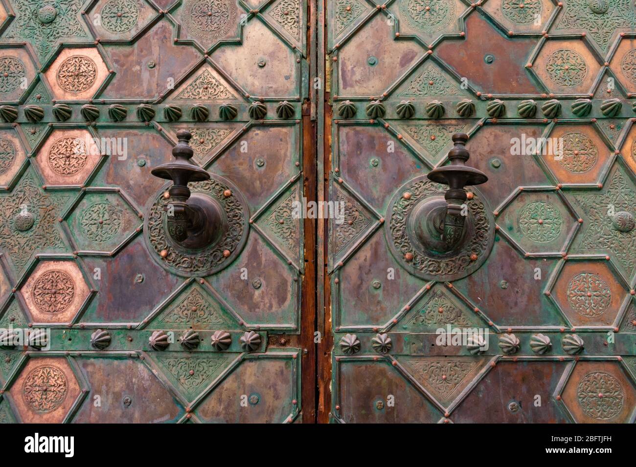 Maniglie ornate su una porta di metallo in una moschea nella Medina di Fez Marocco Foto Stock
