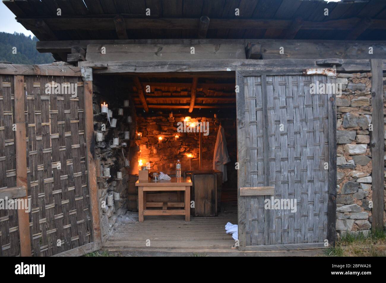 Un bagno tradizionale in pietra calda completo di un fuoco da campeggio e vista della valle di Phobjika, Bhutan. Foto Stock