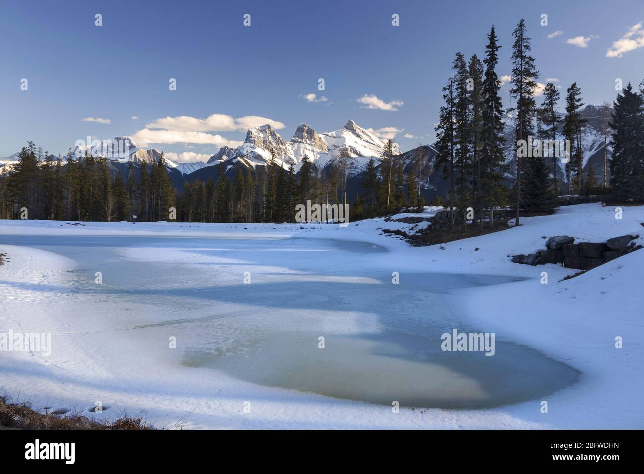 Frozen Lake e Snowy Rocky Mountain Peaks Landscape all'inizio della primavera. Bow Valley, Canmore Alberta Canada Foto Stock