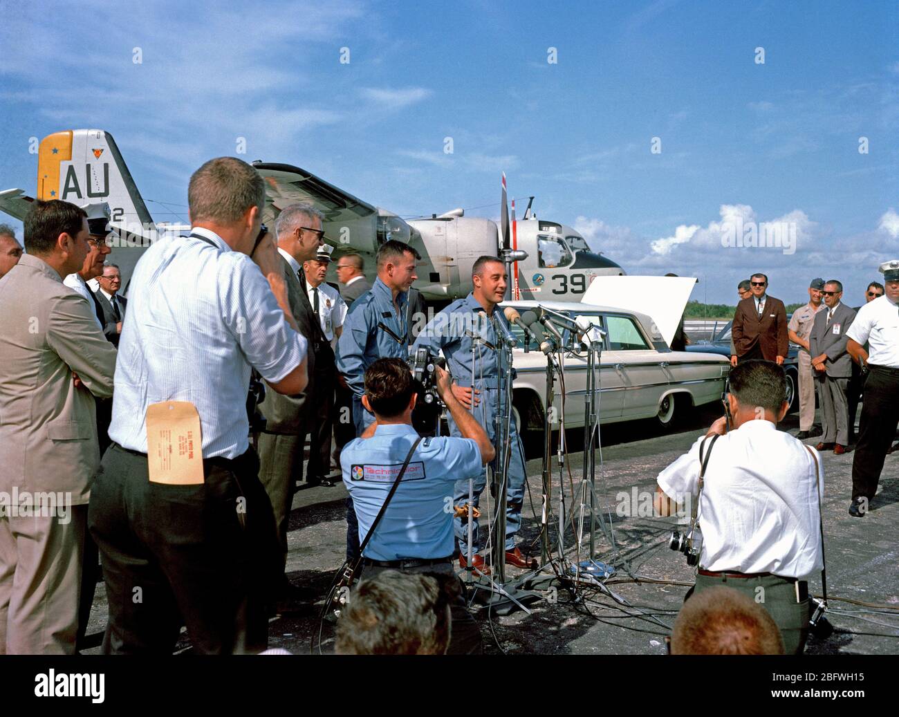Gli astronauti Virgil I. Grissom e John W. Young stand prima di microfoni presso il capo del nastro antiscivolo durante il bentornato cerimonie per la Gemini-Titan 3 crew Foto Stock
